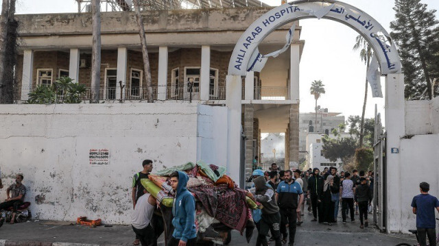 Des Palestiniens transportent des objets utilisables depuis le bâtiment de l'hôpital baptiste Al-Ahli lourdement endommagé après un bombardement dans la ville de Gaza le 18 octobre 2023. Crédit photo: AA