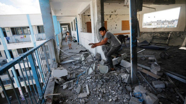 Des enfants palestiniens cherchent des objets utilisables dans une école détruite, gérée par l'Office de secours et de travaux des Nations Unies pour les réfugiés de Palestine (UNRWA) à Gaza le 18 octobre 2023. Crédit photo: AA