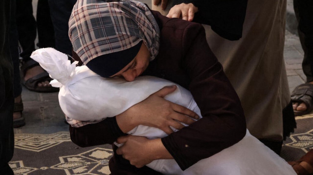 Samia al-Atrash, Palestinienne, porte dans ses bras le corps de l'un des enfants de sa sœur de la famille Khoder, tué lors du bombardement israélien à Rafah, dans le sud de la bande de Gaza, le 21 octobre 2023. Crédit photo: SAID KHATIB / AFP
