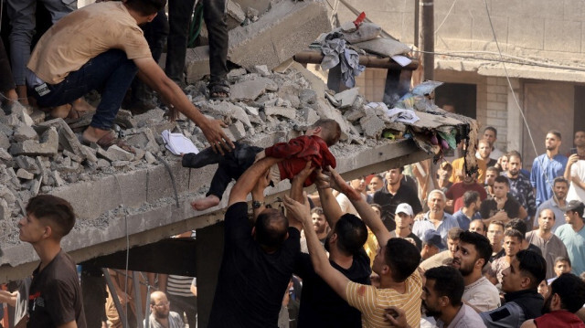 Des civils extraient un enfant dans les décombres d'un bâtiment touché par une frappe aérienne israélienne à Khan Yunis, dans la bande de Gaza, le 24 octobre 2023. Crédit photo: MAHMUD HAMS / AFP
