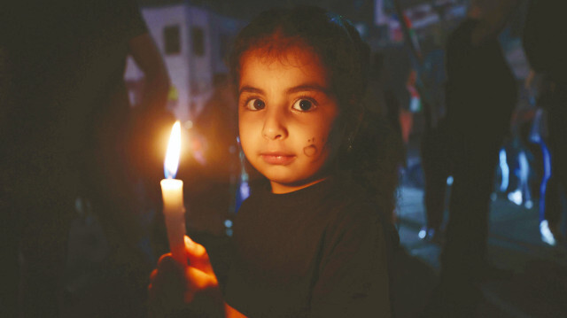 Batı Şeria’nın Ramallah kentinde düzenlenen Gazze’ye destek gösterisinde Filistinliler, hayatını kaybedenlerin anısına mum yaktı.