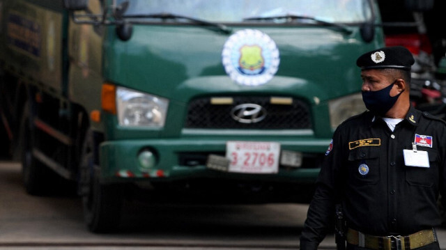 Un policier regarde des prisonniers, arriver dans un camion au Vietnam. Crédit photo: TANG CHHIN SOTHY / AFP / ARCHIVE