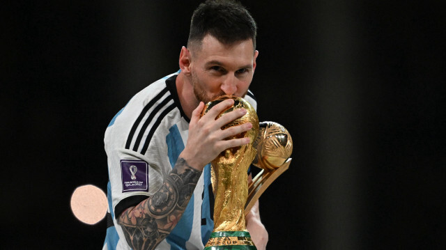 Le footballeur argentin Lionel Messi embrassant la Coupe du Monde de football à Doha, remportée avec l'Argentine face à la France, le 18 décembre 2022. Crédit photo: Paul ELLIS / AFP

