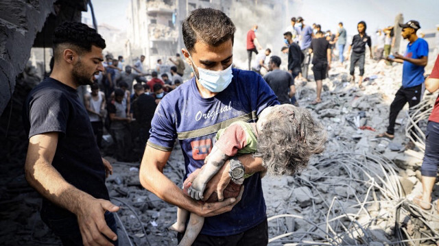 Un Palestinien porte un enfant tué par une frappe aérienne de l'armée d'occupation israélienne sur le camp de réfugiés de Bureij, à Gaza, le 2 novembre 2023. Crédit photo: MAHMUD HAMS / AFP
