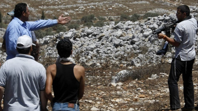 Un colon israélien pointe une arme sur des manifestants palestiniens. Crédit photo: JAAFAR ASHTIYEH / AFP / ARCHIVE