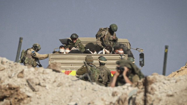 Des soldats israéliens détiennent des palestiniens dans un camion militaire à Gaza, le 19 novembre 2023. Crédit photo: MAHMUD HAMS / AFP