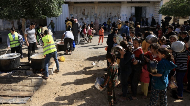 Des enfants réfugiés palestiniens, attendent les repas servis par des volontaires, à Khan Younes, dans le sud de Gaza, le 23 Novembre 2023. Crédit Photo: MAHMUD HAMS / AFP