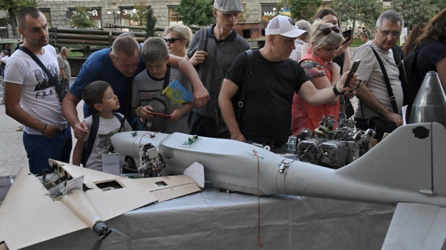 Ukrainiens observant un drone russe abattu par l'armée ukrainienne à Kiev, le 22 aout 2023. Crédit photo: Genya SAVILOV / AFP