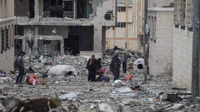 Des citoyens marchent parmi les décombres des bâtiments fortement endommagés par les attaques israéliennes à Gaza, le 28 novembre 2023. Crédit photo: AA