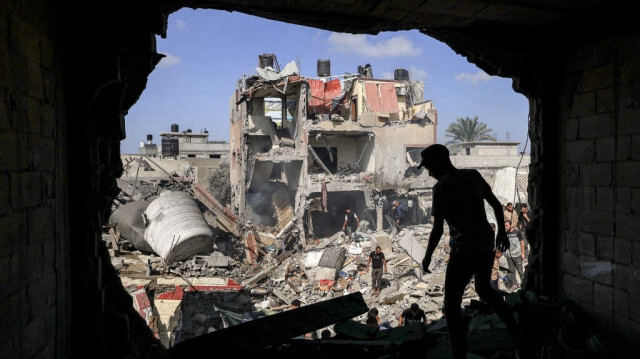 Un jeune Palestinien à l'intérieur un bâtiment touché par une frappe israélienne et d'autres civils fouillent les décombres à la recherche de survivants et de corps de victimes, à Khan Yunis dans la bande de Gaza, le 8 novembre 2023. Crédit photo: MAHMUD HAMS / AFP
