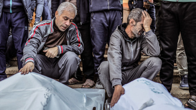 Des personnes en deuil réagissant devant les corps enveloppés de proches tués à la suite de frappes israéliennes, à l'hôpital Nasser de Khan Yunis, dans le sud de la bande de Gaza, le 9 décembre 2023.