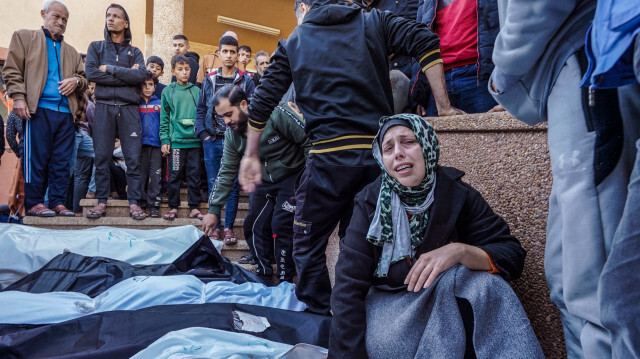 Des personnes en deuil réagissant à côté des corps enveloppés de proches tués par des frappes israéliennes, à l'hôpital Nasser de Khan Yunis, dans le sud de la bande de Gaza, le 9 décembre 2023.