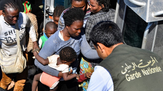 Les migrants d'origine africaine qui tentent de fuir vers l'Europe sont transférés de leur petit bateau sur un navire appartenant aux garde-côtes tunisiens, en mer entre la Tunisie et l'Italie, le 10 août 2023.