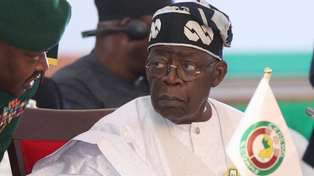 Le président nigérian Bola Tinubu (à droite) s'entretient avec son aide lors de la 64e session ordinaire des présidents d'État et du gouvernement de la Communauté économique des États de l'Afrique de l'Ouest (CEDEAO) à Abuja le 10 décembre 2023.