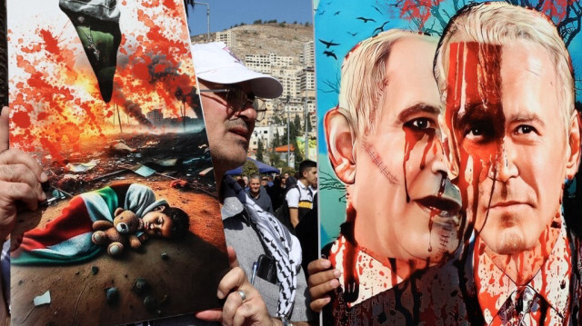 Un manifestant porte une pancarte sur laquelle sont affichés le Premier ministre israélien Benyamin Netanyahu et le président américain Joe Biden, lors d'une marche de soutien à la population de la Bande de Gaza en Cisjordanie occupée, le 26 octobre 2026.