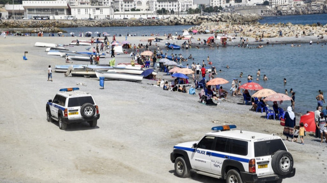 Des véhicules de police passent sur une plage dans la capitale algérienne, Alger, le 15 août 2020.