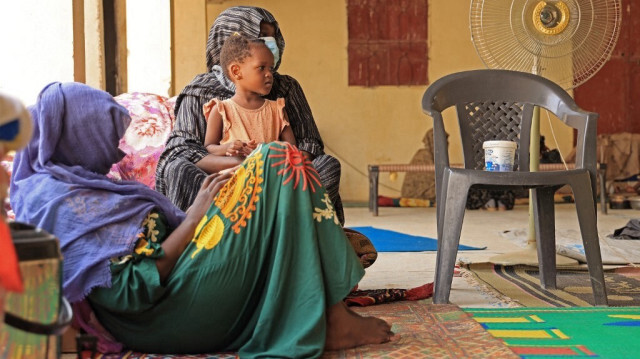 Une femme tient un enfant alors qu'elle est assise avec d'autres personnes déplacées par un conflit dans une mosquée dans la ville frontalière nord du Soudan, Wadi Halfa, près de l'Égypte, le 12 septembre 2023.