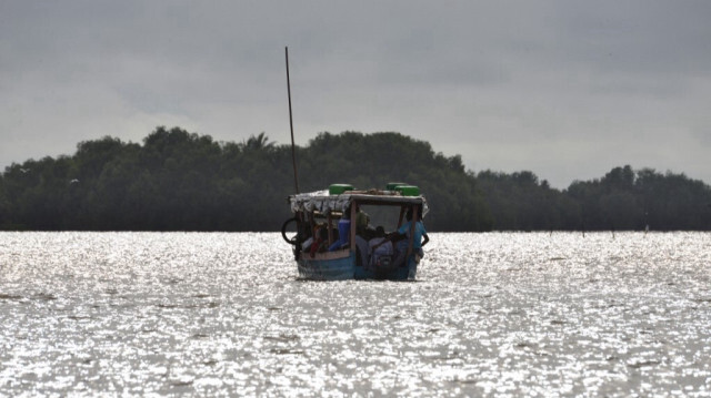 Les gens montent sur un bateau de pêche au large de la côte de la ville ivoirienne de Grand Lahou, située là où la rivière Bandama rencontre le golfe de Guinée, le 15 octobre 2015.