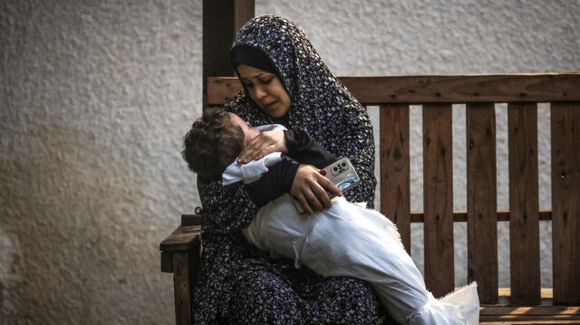 Une femme palestinienne de la famille Ashour porte le corps de son bébé tué lors d'un bombardement israélien, le 14 décembre 2023, à l'hôpital Najar de Rafah, dans le sud de la bande de Gaza.