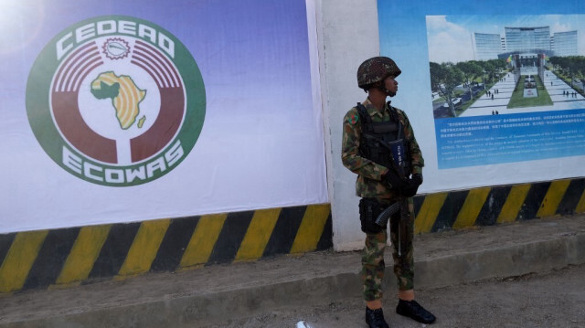 Un soldat nigérian se trouve devant le nouveau chantier de construction du siège de la CEDEAO lors de la cérémonie d'inauguration de la 62e session ordinaire de l'Autorité des chefs d'État et de gouvernement de la CEDEAO à Abuja le 4 décembre 2022.