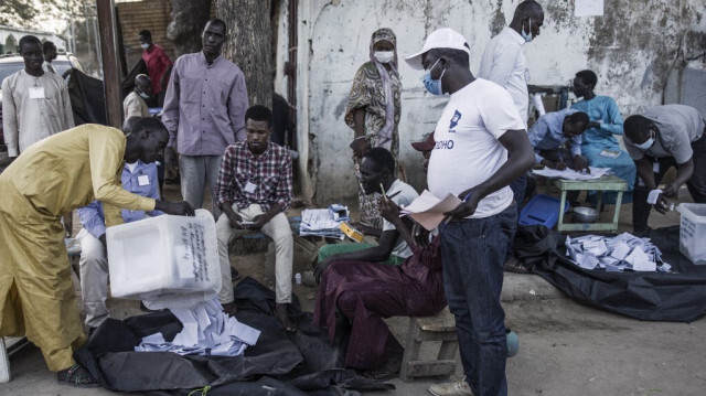 Une urne est vidée à la fin des opérations de vote dans un bureau de vote en bordure de route à N'djamena, tandis que le dépouillement est en cours à un autre le 11 avril 2021.