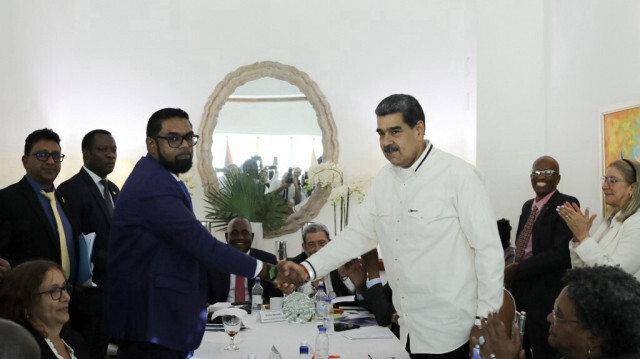 Le président guyanais Irfaan Ali (G) et son homologue vénézuélien, Nicolas Maduro (D)  se serrent la main lors d'une réunion à Saint-Vincent-et-les-Grenadines, le 14 décembre 2023.