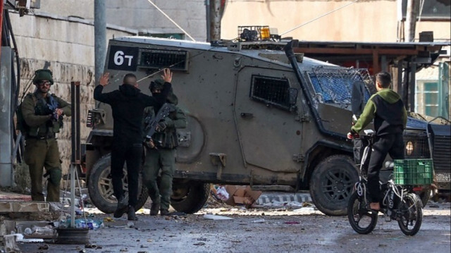 Des soldats de l'armée d'occupation contrôlent un jeune Palestinien en Palestine occupée, le 13 décembre 2023.