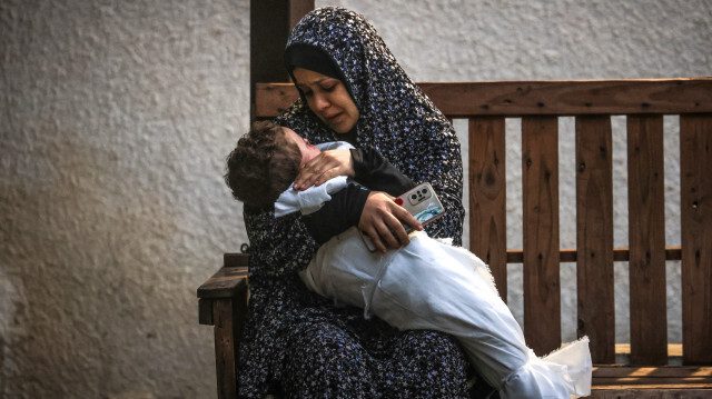 Une femme de la famille palestinienne Ashour tenant le corps d'un bébé qui a été tué lors d'un bombardement israélien, le 14 décembre 2023, à l'hôpital Najar à Rafah, dans le sud de la bande de Gaza.