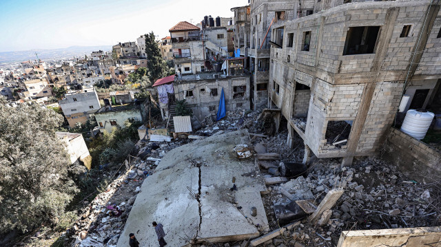 Des hommes se tenant au milieu des décombres d'un bâtiment détruit lors d'une opération de l'armée israélienne dans le camp de réfugiés de Jénine, le 15 décembre 2023.