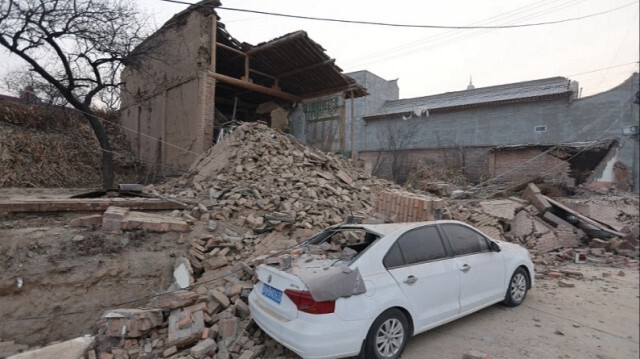 Des bâtiments effondrés et une voiture endommagée après un tremblement de terre au nord-ouest de la Chine, le 19 décembre 2023.