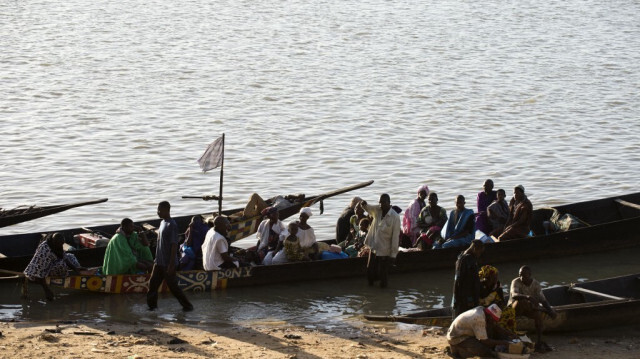 Les passagers sont assis dans un bateau dit Pinasse avant de traverser la rivière Bani, une branche du fleuve Niger, au port commercial de la ville septentrionale de Mopti le 15 mars 2013. 