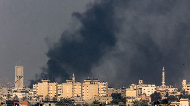 Une photo prise de Rafah montre de la fumée qui se projette au-dessus de Khan Yunes dans le sud de la bande de Gaza lors du bombardement des colons israéliens du 19 décembre 2023.