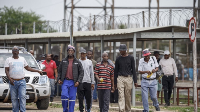 Des mineurs marchent après avoir refait surface, en raison de problèmes de santé, après la manifestation souterraine à la mine de platine Bafokeng Rasimone près de Rustenburg en Afrique du Sud, le 19 décembre 2023.