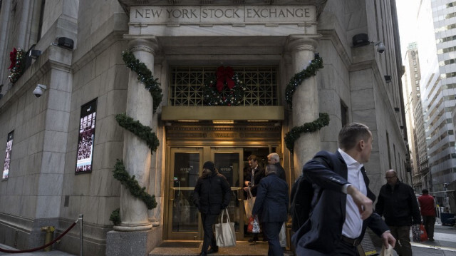 Des gens entrent et sortent de la Bourse de New York (NYSE) à Wall Street, le 14 décembre 2023 à New York. 