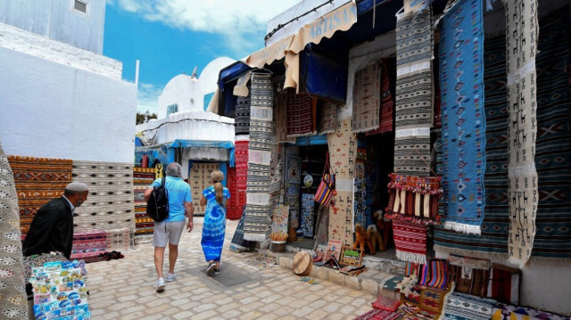 Des touristes visitent un marché d'artisanat sur l'île touristique de Djerba en Tunisie le 11 mai 2023.