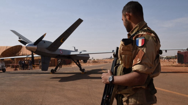 Un soldat français du détachement aérien de l'opération Barkhane garde près d'un drone Reaper à l'aéroport militaire nigérian Diori Hamani à Niamey au Niger le 2 janvier 2015.