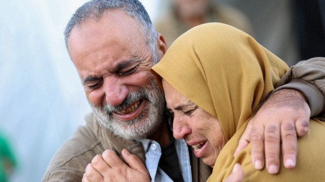 Des Palestiniens réagissant dans la cour d'un hôpital alors que des victimes de bombardements israéliens sont amenées, à Deir al-Balah, dans le centre de la bande de Gaza, le 20 décembre 2023.