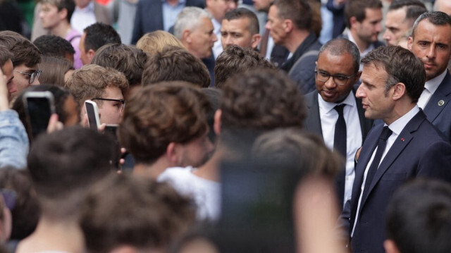 Le président français Emmanuel Macron serre la main des élèves après son discours lors d'une visite au lycée Bernard Palissy, le 4 mai 2023.