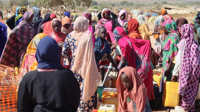 Les réfugiés fuyant le conflit au Soudan font la queue avec leurs bidons pour avoir de l'eau potable au point de distribution de Médecins sans frontières (MSF) au camp de réfugiés d'Ourang à Adre le 7 décembre 2023.