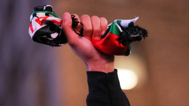 Une personne tend le drapeau palestinien pendant une manifestation mondiale en faveur de Gaza le 18 décembre 2023, à New York.