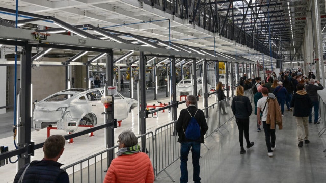 Les visiteurs se promènent dans un bâtiment d'usine lors de l'ouverture de la nouvelle "Gigafactory" du constructeur automobile américain Tesla à Gruenheide, à l'est de la capitale allemande Berlin, le 9 octobre 2021.