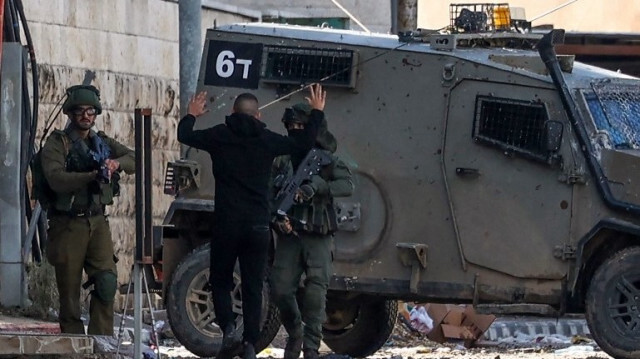 Un soldat israélien contrôle un jeune Palestinien à Jénine, le 13 décembre 2023