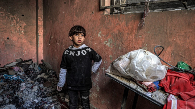 Un enfant Palestinien au milieu des décombres des logements détruits par les bombardements de l'armée d'occupation israélienne à Rafah, dans le sud de la bande de Gaza, le 24 décembre 2023.