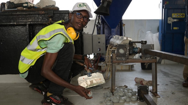 Un entrepreneur sénégalais ramasse des balles en plastique recyclées lors d'une formation technique dans un atelier de recyclage le 22 février 2023.