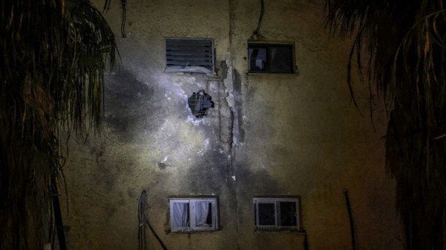 Un cratère sur le mur d'un bâtiment dans la ville frontalière de Kiryat Shmona, au nord d'Israël, le 27 décembre 2023.