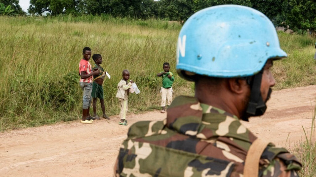 Les enfants regardent un soldat des Nations Unies (ONU) faisant partie de la MINUSCA (Mission multidimensionnelle de stabilisation intégrée des Nations Unies en République centrafricaine) sur la route de Koui, en République centrafricaine, le 24 septembre 2020.