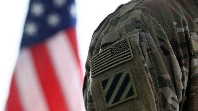 Un soldat américain près d'un drapeau américain sur la base d'entraînement militaire de l'armée américaine à Grafenwoehr, dans le sud de l'Allemagne, le 11 mars 2022.
