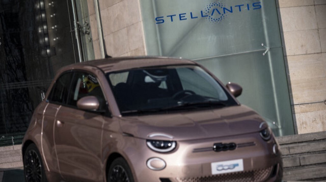 La voiture électrique Fiat Prima 500 affichée devant le logo de Stellantis, la société forgée en méga-fusion de Fiat et Peugeot, après avoir été ajoutée sur la façade de l'usine automobile Fiat Mirafiori à Turin, dans le nord de l'Italie.