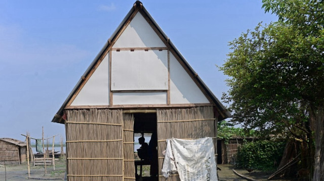 Une photo prise le 3 septembre 2023 montrant un homme assis à l'intérieur d'un abri modulaire mobile appelé "Khudi Bari" ou "tiny house" à Char Shildaha au Bangladesh.