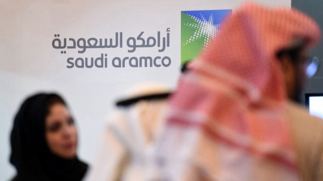 Les investisseurs saoudiens et étrangers se tiennent devant le logo du géant pétrolier de l'État saoudien Aramco lors du 10e Forum mondial sur la compétitivité le 25 janvier 2016, dans la capitale saoudienne, Riyad.